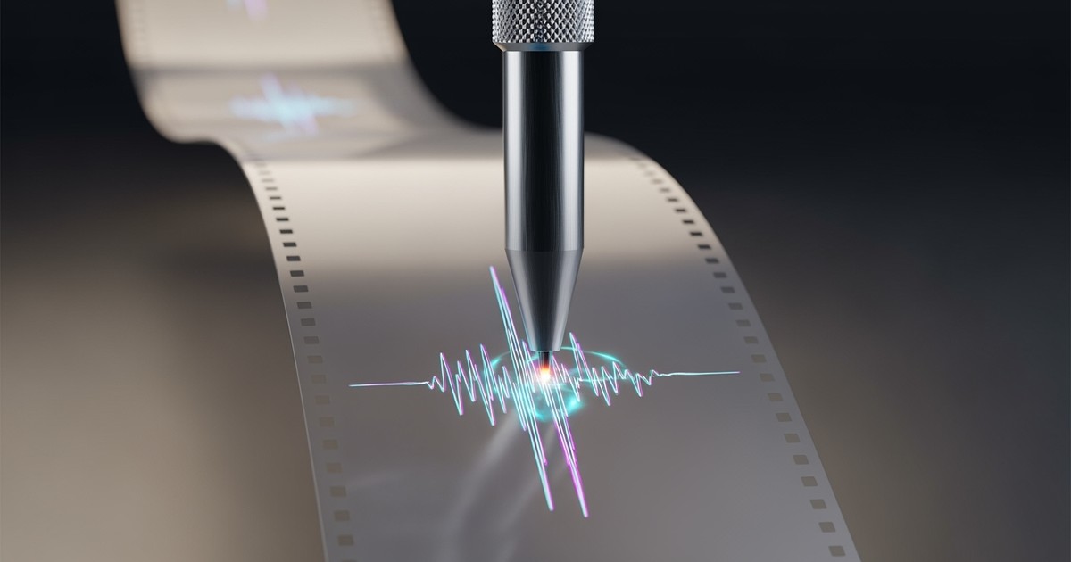 A close-up, hyper-realistic 3D render of a precision metallic stylus etching a glowing waveform onto a rapidly scrolling vertical ribbon of
